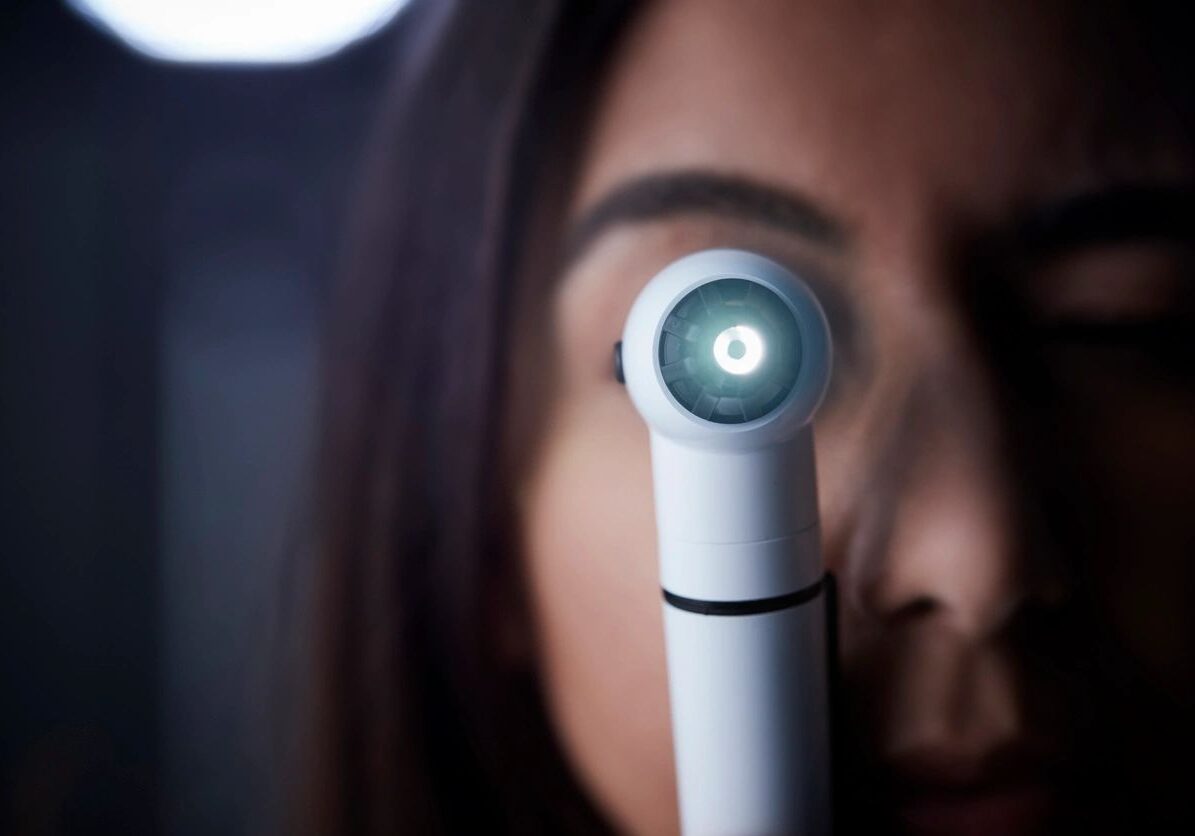 Female doctor using otoscope for examination, close up